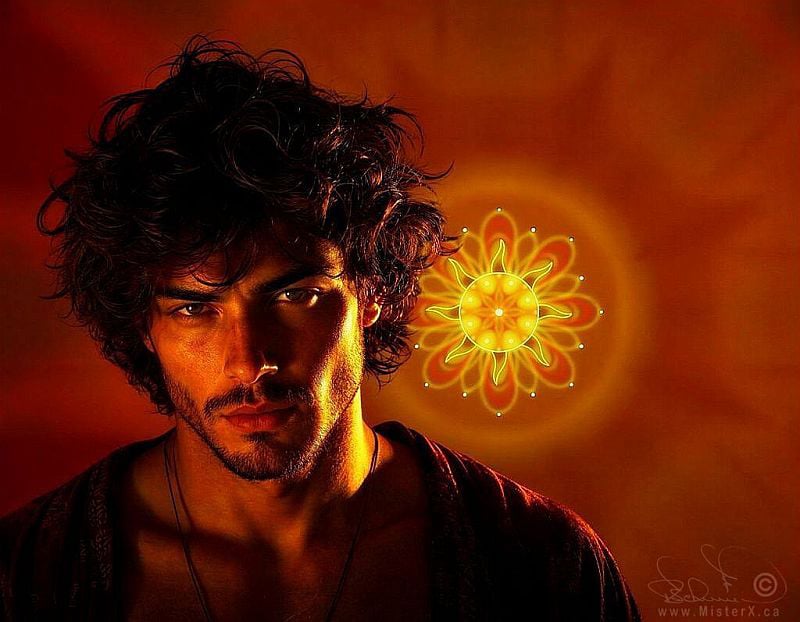 This striking digital portrait features a man with a fierce, intense gaze, framed by thick, unruly dark curls and a well-defined stubble beard. He is illuminated by a dramatic, high-contrast golden light that carves out his sharp facial features, leaving the right side of his face cast in deep shadow. Behind his left shoulder, a vibrant, glowing yellow and orange mandala pattern radiates outwards, echoing the warm, fiery tones of the dark amber background. The overall composition creates a powerful, mystical atmosphere, enhanced by the man's direct, compelling stare and the symbolic, sun-like emblem hovering beside him.