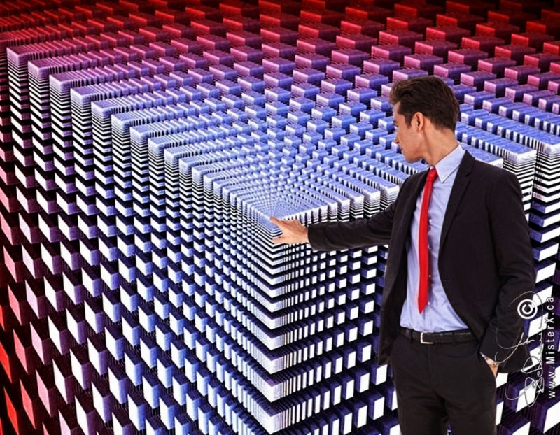 A man in a business suit looks back at and points to the center of a geometric design composed of squares and rectangles that appear to go off into infinity.